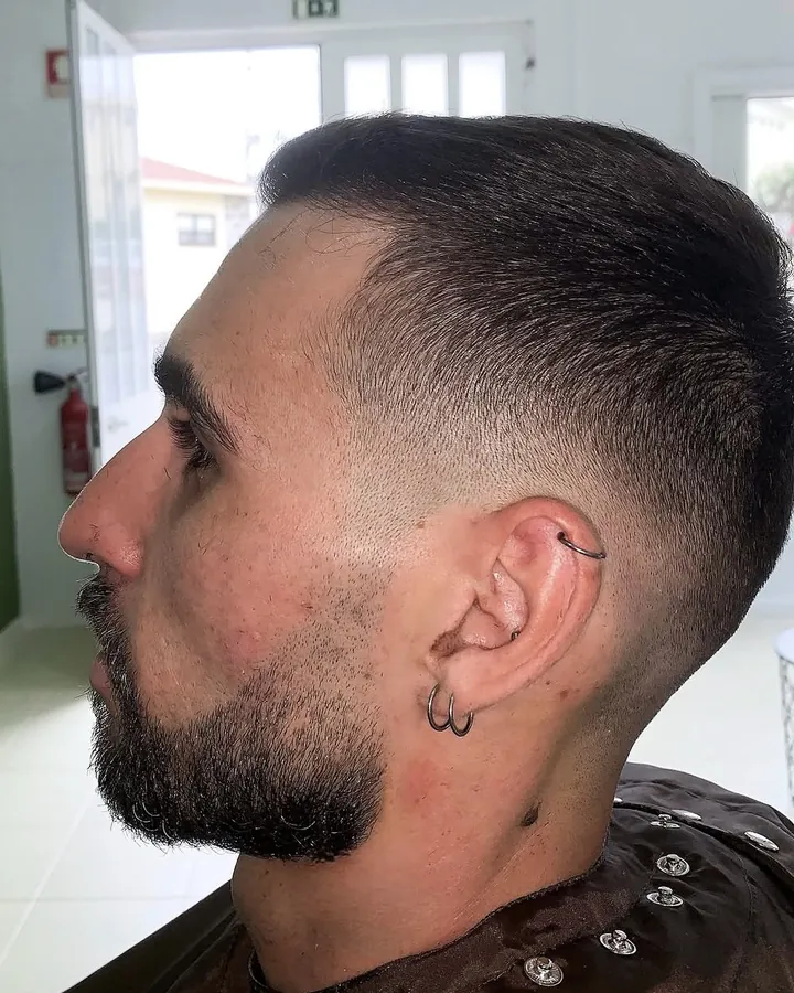 Perfil com skin fade nas têmporas e barba desenhada